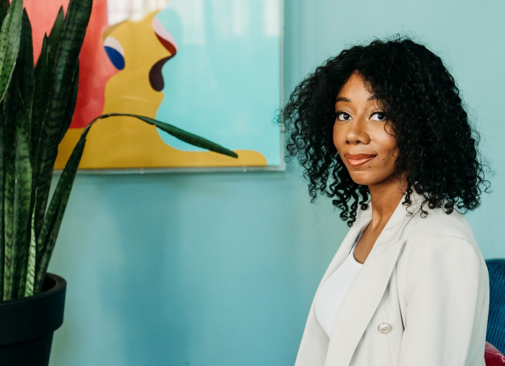 Teresa Richards, freelance SEO blogger sitting in a chair wearing a white jacket and top looking at the camera